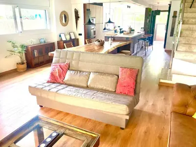 a living room with a couch and a kitchen at Alma Castellana, Casa en plena Naturaleza in Dosríus