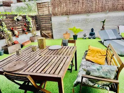a patio with a wooden table and a couch at Alma Castellana, Casa en plena Naturaleza in Dosríus