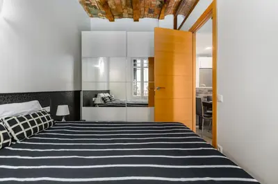 a bedroom with a bed with a black and white striped blanket at Space & Privacy Terrace, AC, Central Gràcia in Barcelona