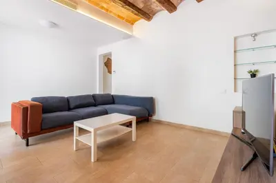 a living room with a blue couch and a table at Space & Privacy Terrace, AC, Central Gràcia in Barcelona