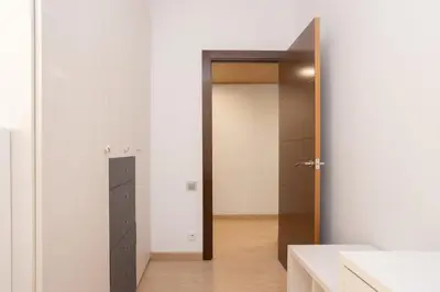 a hallway with a door leading to a bedroom with white walls at Sunny Beachside Haven 2 BD in the Marina District in Barcelona