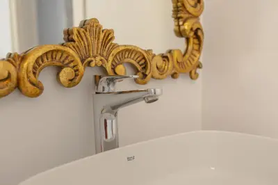 a bathroom sink with a gold faucet at Villa Conde in Hospitalet de Llobregat