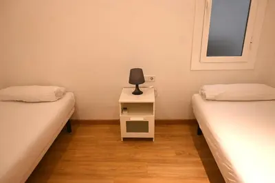 a room with two beds and a table with a lamp on it at Homenfun Barcelona Paseo de Gracia in Barcelona