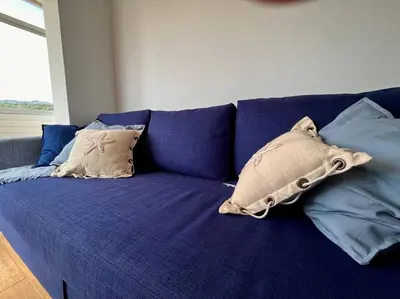 a blue couch with several pillows on it at Apartamento “La Caleta” in Calella