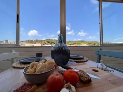 a table with a bowl of food and a vase at Apartamento “La Caleta” in Calella