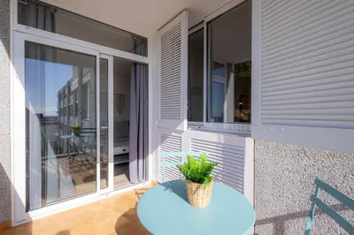 a balcony with a blue table and a plant on it at Hauzify I Apartaments Can Pi in San Pol de Mar