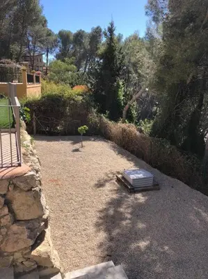 a garden with a bench and a stone wall at Villa Barcelona en Olivella in Olivella