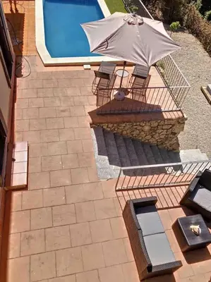 an overhead view of a pool with an umbrella and chairs at Villa Barcelona en Olivella in Olivella