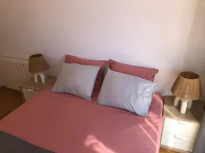 a bed with two pillows and two lamps on tables at Villa Barcelona en Olivella in Olivella