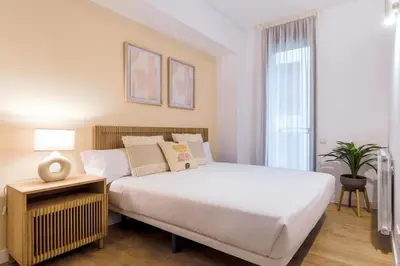 a bedroom with a white bed and a window at CATERINA Gràcia in Barcelona