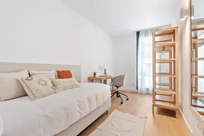 a white bedroom with a bed and a desk at CATERINA Gràcia in Barcelona