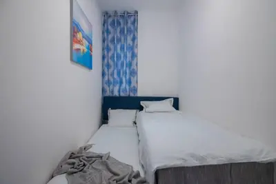 a small bedroom with two beds and a window at +25Y ONLY, Family flat near the beach in Barcelona