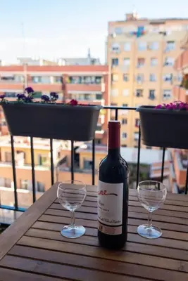 a bottle of wine and two wine glasses on a table at +25Y ONLY, Family flat near the beach in Barcelona