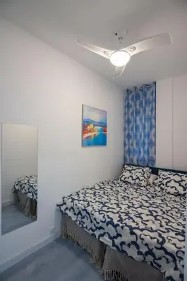 a bedroom with a bed and a ceiling fan at +25Y ONLY, Family flat near the beach in Barcelona