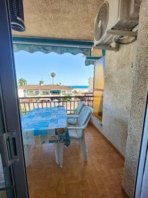 a living room with a couch and a view of the ocean at Apartamento en la playa in Cunit