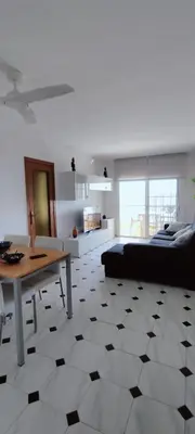 a bedroom with a bed with a red blanket and a window at Apartamento en la playa in Cunit