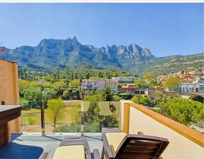 a desk with a chair and a television on a wall at Apartamento en Montserrat- Montserrat Paradise Apartament in Monistrol