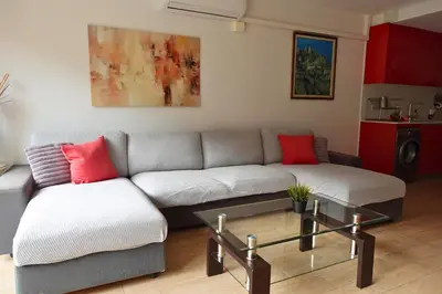 a bed and a couch with two red pillows at Apartamento en Montserrat- Montserrat Paradise Apartament in Monistrol