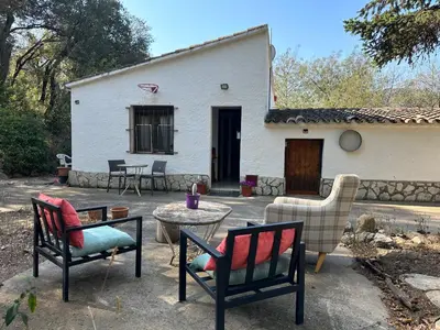 a patio with chairs and a table in front of a house at Can Ginesta Muy feliz&tranquilo in Barcelona