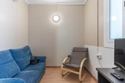 a living room with a blue couch and a chair at AB Vila i Vila Apartments in Barcelona