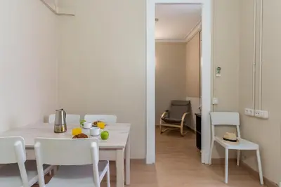 a white dining room with a table and chairs at AB Vila i Vila Apartments in Barcelona