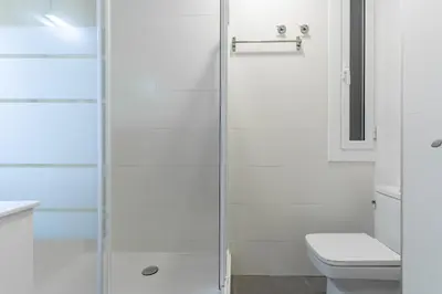 a bathroom with a glass shower with a toilet at AB Vila i Vila Apartments in Barcelona
