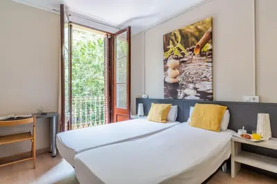 a bedroom with a large white bed and a window at AB Vila i Vila Apartments in Barcelona
