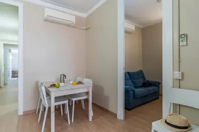 a living room with a table and a blue couch at AB Vila i Vila Apartments in Barcelona