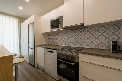 a kitchen with white cabinets and a stove top oven at CATERINA Mar Bella in Barcelona