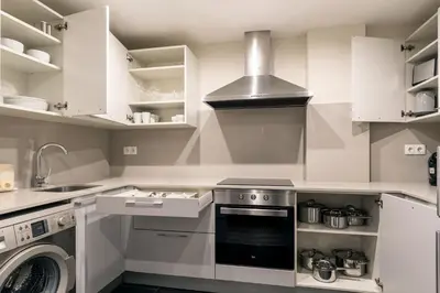 a kitchen with white cabinets and a stove top oven at CATERINA Mar Bella in Barcelona