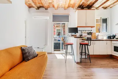 a living room with a couch and a kitchen at Beachside Bliss Charming 1-bedroom, Barceloneta in Barcelona
