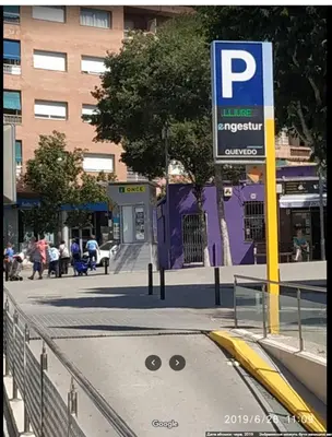 a parking meter on a city street with a parking sign at metro La Salut in Badalona