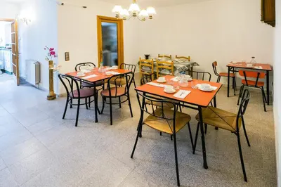 a dining room with orange tables and chairs at L'Hostalet GuestHouse in Pineda de Mar