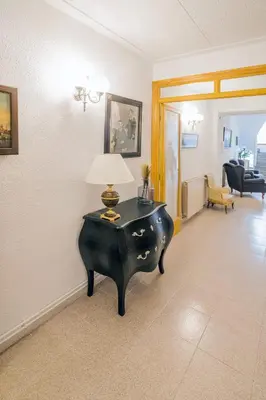 a living room with a table with a lamp on it at L'Hostalet GuestHouse in Pineda de Mar