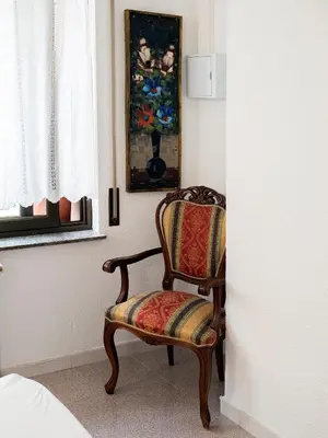 a chair sitting next to a window in a room at L'Hostalet GuestHouse in Pineda de Mar