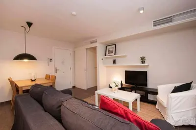 a living room with a couch and a table at Port VII Apt centrico acogedor w balcon 23 in Barcelona