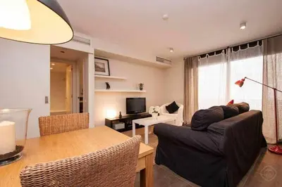 a living room with a couch and a table at Port VII Apt centrico acogedor w balcon 23 in Barcelona