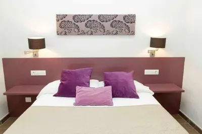 a bedroom with a bed with purple pillows at Port III Apart céntrico ideal familias 11 in Barcelona