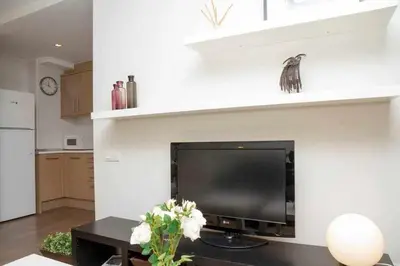 a living room with a flat screen tv on a wall at Port III Apart céntrico ideal familias 11 in Barcelona