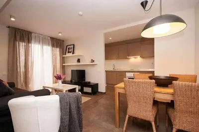 a living room with a table and chairs and a kitchen at Port IV Apart céntrico ideal grupos 12 in Barcelona