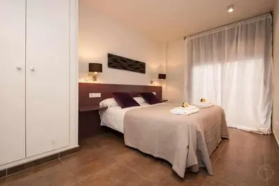 a bedroom with two beds and a large window at Port IV Apart céntrico ideal grupos 12 in Barcelona