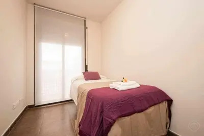 a bedroom with a bed and a large window at Port IV Apart céntrico ideal grupos 12 in Barcelona