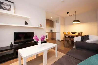 a living room with a couch and a table with flowers at Port IV Apart céntrico ideal grupos 12 in Barcelona