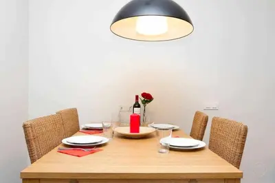 a wooden table with chairs and a bottle of wine at Port VI Apart céntrico ideal familias 22 in Barcelona