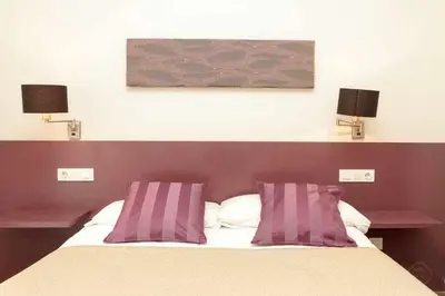 a bedroom with a bed with purple and white pillows at Port VI Apart céntrico ideal familias 22 in Barcelona