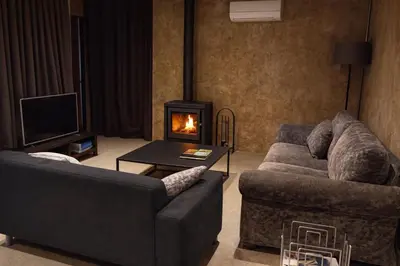 a living room with a couch and a fireplace at Masia Cal Sisplau, con piscina y rodeada de viñedos a 10 minutos de Vilafranca del Penedés, Barcelona ,Cataluña in San Martín Sarroca