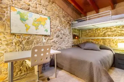 a bedroom with a bed and a desk and a map at Masia Cal Sisplau, con piscina y rodeada de viñedos a 10 minutos de Vilafranca del Penedés, Barcelona ,Cataluña in San Martín Sarroca