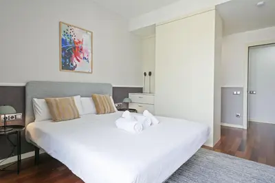 a bedroom with a large white bed with towels on it at Ola Living Plaza Catalunya in Barcelona