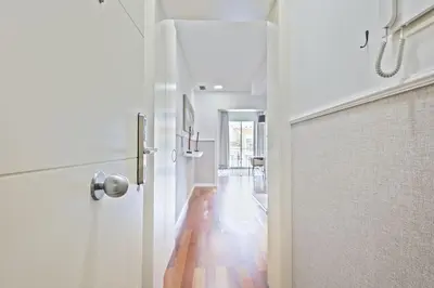 a hallway with a white door and a hallway with wooden floors at Ola Living Plaza Catalunya in Barcelona