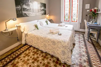 a bedroom with a large bed with a table and a desk at Casa del Mediterraneo in Barcelona